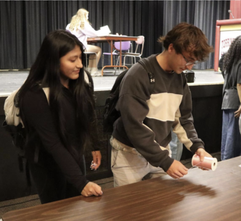 Interact Members Melissa Duman and Dylan Moore making ribbons for breast cancer awareness.